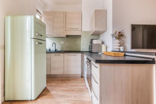 a kitchen with white appliances and a refrigerator at 4 Pax Wi-Fi Milano Lorenteggio in Milan