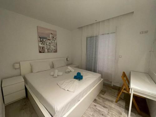 Un dormitorio con una cama blanca con dos velas. en Blue Fish, en Pefkohori