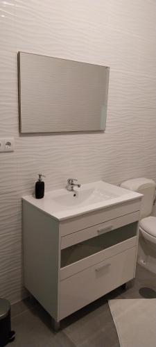 a white bathroom with a sink and a toilet at Studio Fons in Abragão