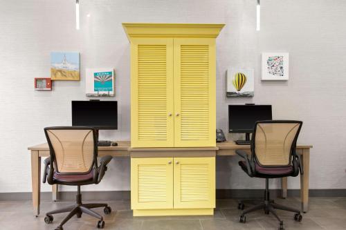 フェニックスにあるHome2 Suites By Hilton Phoenix Downtownの椅子2脚と黄色いキャビネットが付いた机