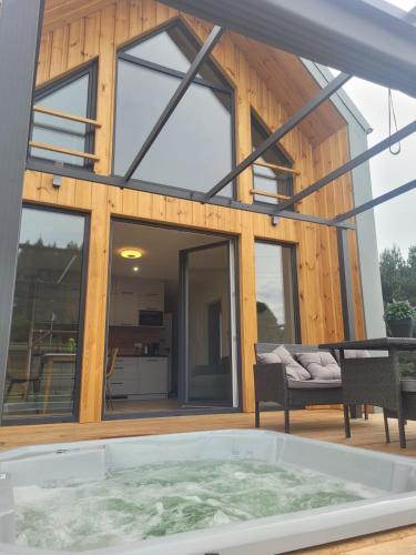 a house with a large window and a tub at Parkcity SPA Domek z jacuzzi w górach in Biała Niżna