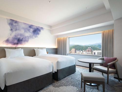 a hotel room with two beds and a window at Grand Mercure Sapporo Odori Park in Sapporo