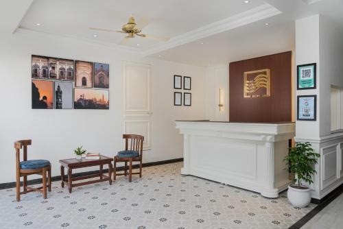 a lobby with a fireplace and chairs and a table at Hotel Ganga Maiya in Lucknow