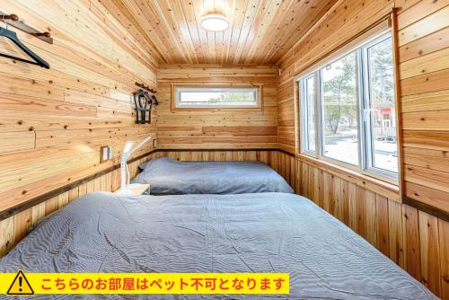 Postel nebo postele na pokoji v ubytování ログコテージ風の丘