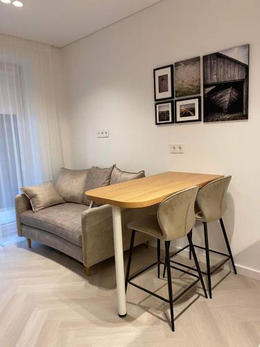 a living room with a table and a couch at 11 New Airport Apartment - Nedirba in Vilnius