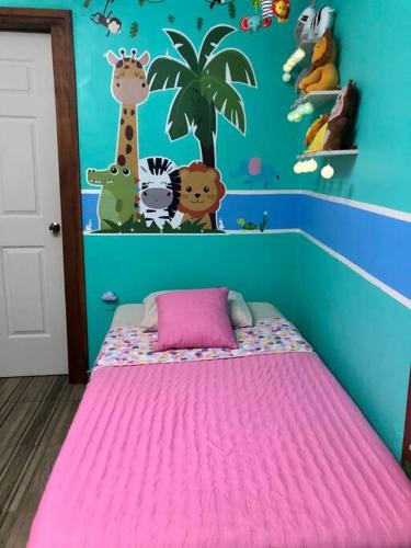 a childs room with a bed with a pink blanket at Departamento Céntrico, acogedor, comodo, pequeño in Orizaba