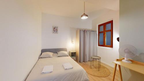 une chambre blanche avec un lit et un bureau dans l'établissement T3 Spacieux - Proche gare - Entièrement rénové, à Marseille