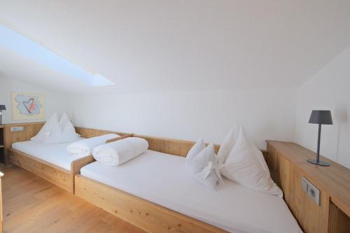 two beds in a room with white sheets and pillows at Chalet Stubai inklusive Stubai Super Card in Fulpmes