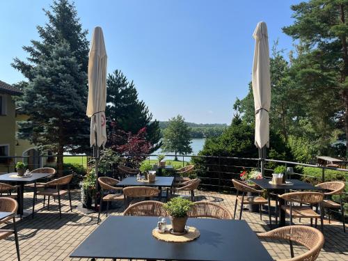 a patio with tables and chairs and umbrellas at Resort-Restaurant Stilec in Kamenný Újezd