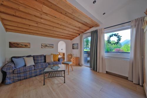 a living room with a couch and a large window at Chalet Stubai inklusive Stubai Super Card in Fulpmes
