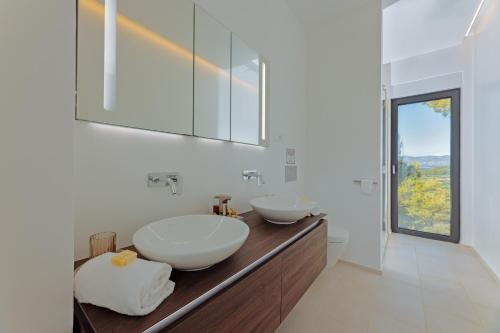 a bathroom with two sinks on a wooden counter at Stylish Lumbarda Villa Sleeps 10 with Private Pool in Lumbarda
