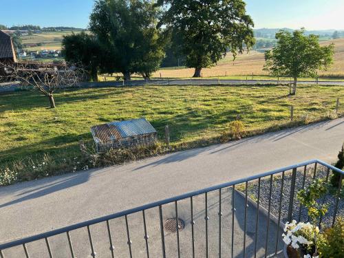 a bench sitting on a road next to a field at C&C motorhome/RV/caravan/van park in La Sonnaz