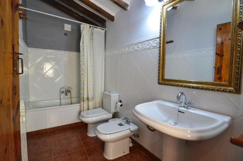 a bathroom with a sink and a toilet and a mirror at Casa Rural en la Montaña Mas de Tenesa in Benasal