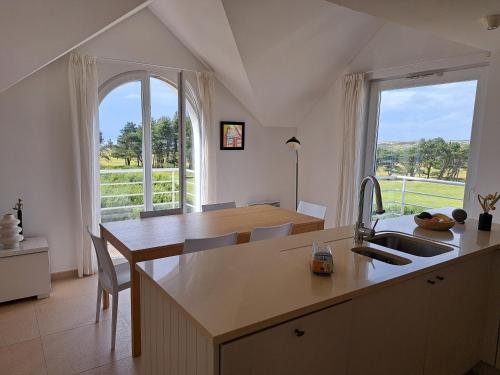 une cuisine avec un évier et une grande fenêtre dans l'établissement Happy wim', à Wimereux
