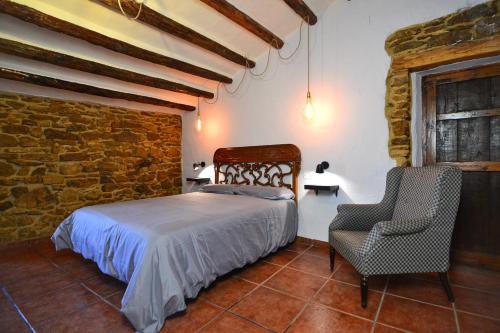 a bedroom with a bed and a chair at Casa Rural en la Montaña Mas de Tenesa in Benasal