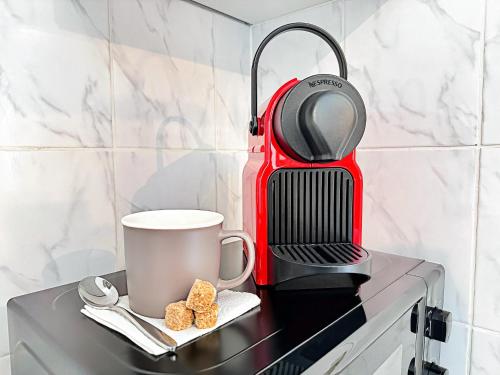 a coffee maker and a cup on a stove at Suite Flamenco Check in h24 - Wifi in Oullins
