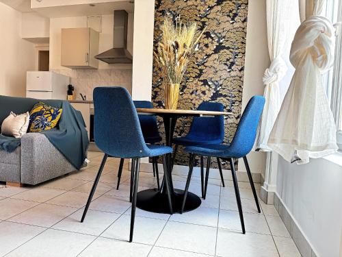a dining room with a table and blue chairs at Suite Flamenco Check in h24 - Wifi in Oullins