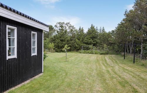 a black house with a soccer ball in a field at 4 Bedroom Lovely Home In Vestervig in Vestervig