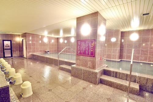 a large bathroom with a swimming pool and toilets at Okayama Universal Hotel Annex 2 in Okayama