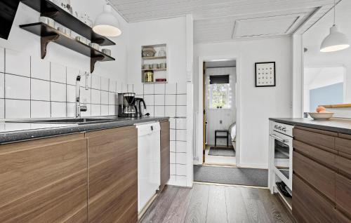 a kitchen with white walls and wooden cabinets at 4 Bedroom Lovely Home In Vestervig in Vestervig
