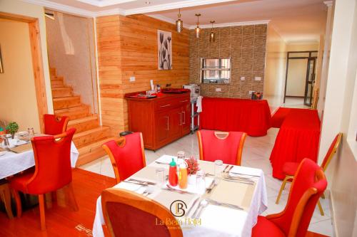 a dining room with red chairs and a table at LA BEILA HOTEL MERU in Meru