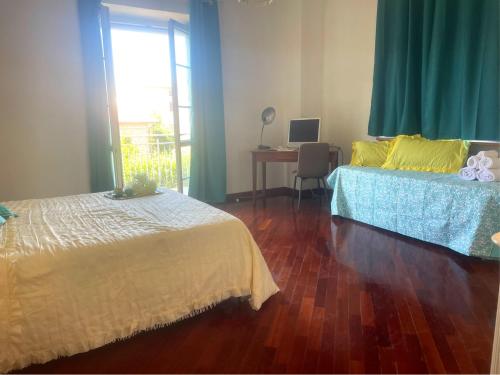 a bedroom with two beds and a desk and a window at Sunshine in Sanfatucchio