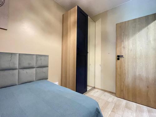 Un dormitorio con una cama y una puerta de madera. en Superior Baltea 2 rooms, 1 bedroom, Beach 800m, Air Condition! Terrace, en Gdansk