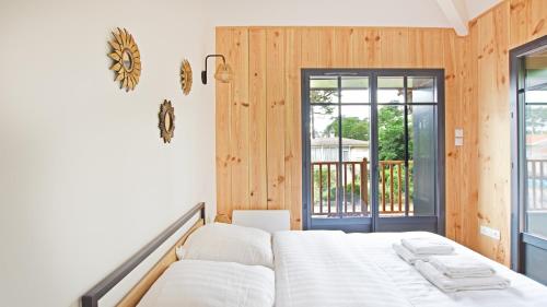 une chambre avec un lit et une porte coulissante en verre dans l'établissement Maison 5 chambres Petit Piquey, à Lège-Cap-Ferret