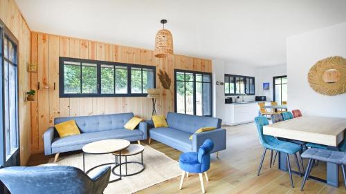 - un salon doté d'un mobilier bleu et d'une table dans l'établissement Maison 5 chambres Petit Piquey, à Lège-Cap-Ferret