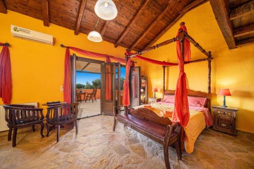 a bedroom with a canopy bed and a table and chairs at Villa Nostos by Villa Plus in Svoronata
