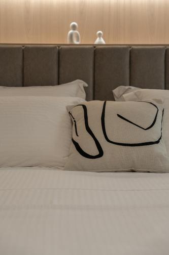 a bed with white pillows on top of it at Piccadill Luxury Villas in Methoni