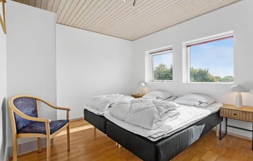 a bedroom with a bed and a chair and a window at Amazing Home In Vesløs With Wifi in Øsløs