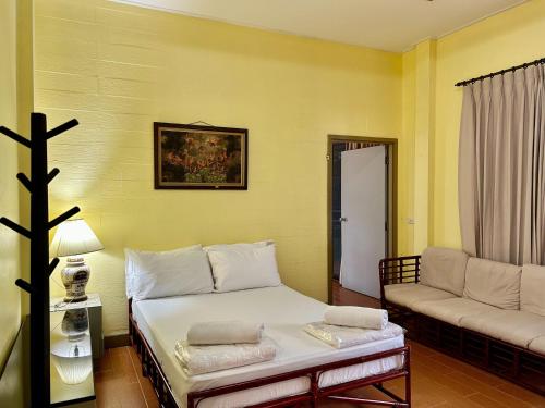 a small room with a bed and a couch at Baan Napapan Beach Front, Hua Hin in Hua Hin
