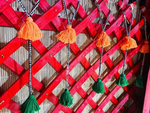 a wall with red and green tassels on it at Tien Shan Yurt in Bishkek