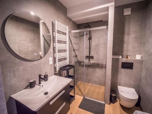 a bathroom with a sink and a toilet and a mirror at Art Boulevard in Mrzeżyno