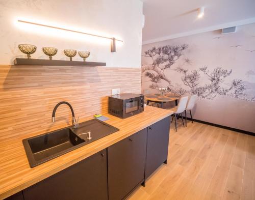 a kitchen with a sink and a table with chairs at Art Boulevard in Mrzeżyno
