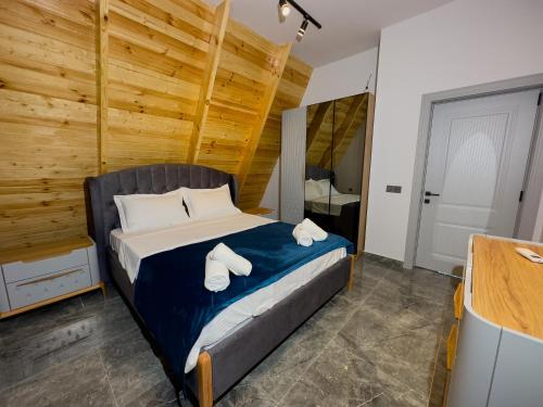a bedroom with a bed with towels on it at Qafqaz Wooden Chalet in Gabala
