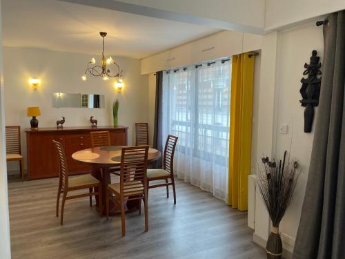 une salle à manger et une cuisine avec une table et des chaises dans l'établissement Proche de la Campagne à Paris, à Paris