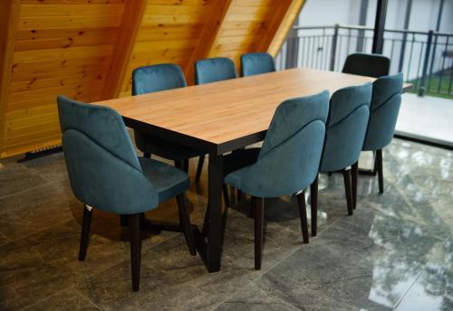 a conference room with a wooden table and blue chairs at Qafqaz Wooden Chalet in Gabala