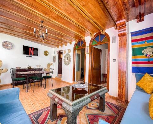 un salon avec un canapé bleu et une table dans l'établissement Dar Statia 3 vue mer, à El Jadida