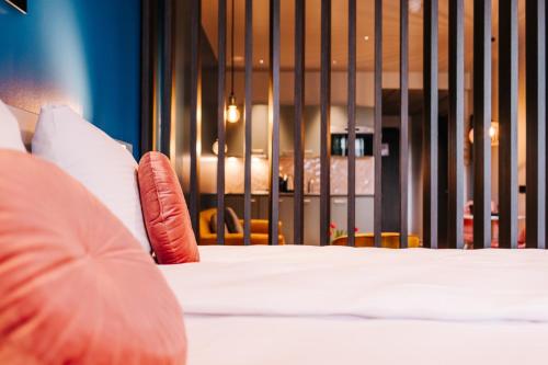 a bedroom with a bed with pillows and a fence at Hotel Keur - Apartments in Zandvoort