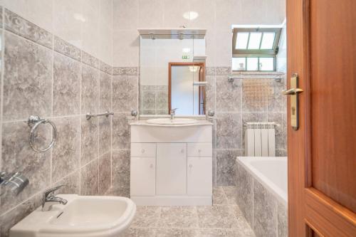 a bathroom with a sink and a toilet and a tub at Casa Sejões - Gêres in Terras de Bouro