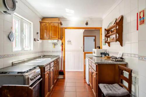 a kitchen with a sink and a stove top oven at Casa do Limoeiro 2 in Valezim
