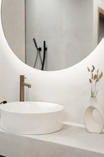 a white bathroom with a sink and a mirror at Piccadill Luxury Villas in Methoni