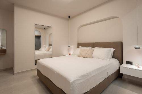 a bedroom with a large white bed and a mirror at Piccadill Luxury Villas in Methoni