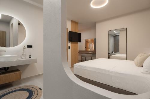 a bedroom with a bed and a sink and a mirror at Piccadill Luxury Villas in Methoni