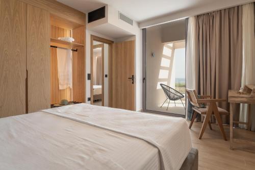 a bedroom with a bed and a desk and a chair at Piccadill Luxury Villas in Methoni