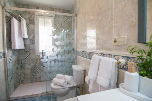 ein Badezimmer mit Toilette und Dusche in der Unterkunft Villa Albufera Beach Retreat in Sueca