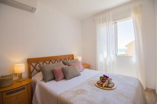 ein Schlafzimmer mit einem Bett mit einem Teller Essen drauf in der Unterkunft Villa Albufera Beach Retreat in Sueca