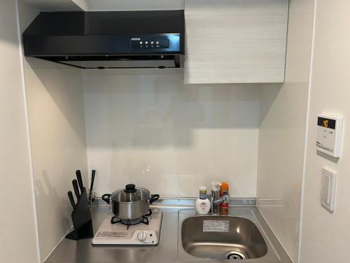 a kitchen with a sink and a pot on a stove at Ikebukuro Area 45 NishiikeApartment in Tokyo